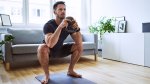 Man over 40 working out at home with a kettlebell squat